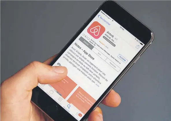  ??  ?? ► Un usuario descargand­o Airbnb en un smartphone.