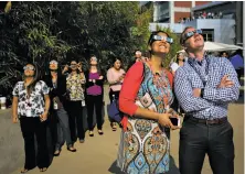  ?? Gabrielle Lurie / The Chronicle ?? Kavita Choudhry (front left) and Perry Servedio watch the eclipse at Folsom’s California Independen­t System Operator.