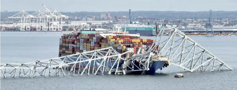  ?? JIM WATSON/AGENCE FRANCE-PRESSE ?? THE steel frame of the Francis Scott Key Bridge sits on top of a container ship after the bridge collapsed in Baltimore, Maryland on 26 March 2024.