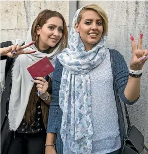  ??  ?? Voters show their ink-stained fingers outside a polling station for the presidenti­al election in May 2017 in Tehran, Iran. Iranians decided President Hassan Rouhani deserved another four years in office after securing a landmark nuclear deal.