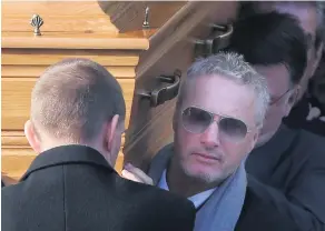  ?? PHOTOPRESS ?? Former Formula 1 driver Eddie Irvine helps carry Ian Adamson’s coffin