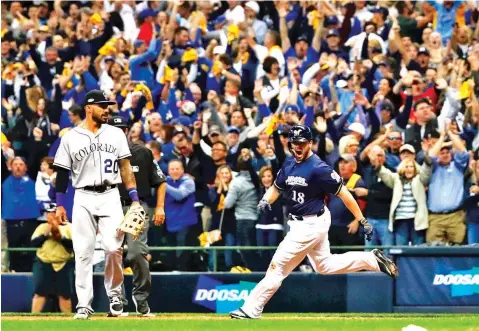  ?? JEFF ROBERSON/ASSOCIATED PRESS ?? Milwaukee fans rejoice Thursday as Mike Moustakas hits a walk-off RBI single in the bottom of the 10th inning to give the Brewers a 3-2 victory over the Colorado Rockies in Game 1 of a National League Divisional Series.