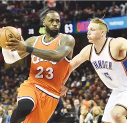  ?? (Reuters) ?? CLEVELAND CAVALIERS forward LeBron James drives to the basket against Oklahoma City Thunder defender Kyle Singler during the second half of the Cavs’ 107-91 Sunday night home victory, in which James had 25 points to top 20,000 for his combined...