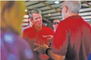  ?? STAFF PHOTOS BY TROY STOLT ?? Georgia Gov. Brian Kemp speaks with a supporter during the Floyd County GOP Rally at the Coosa Valley Fairground­s on Saturday in Rome, Ga.