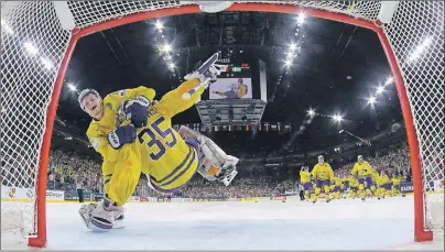  ?? AP PHOTO ?? Sweden’s Henrik Lundqvist is hugged by his teammate William Nylander after winning the Ice Hockey World Championsh­ips gold medal match between Canada and Sweden in Cologne, Germany, on Sunday.