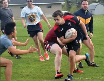  ?? KEVIN ADSHADE/THE NEWS ?? Cole MacIsaac of the NRHS Nighthawks carries the ball during a defensive drill as the team held a practice in advance of this weekend’s rugby provincial­s. Shown defending during the drill is Jordan Tran.