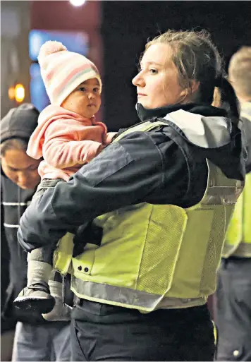  ?? ?? A migrant child is cared for by RNLI staff after arriving at Dungeness lifeboat station in Kent after making the crossing by boat
