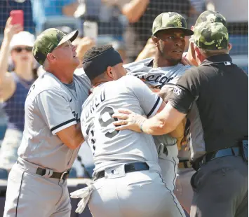  ?? SARAH STIER/GETTY ?? Jose Abreu (79) holds back shortstop Tim Anderson during a benches-clearing dispute in a game against the Yankees on Saturday in New York.