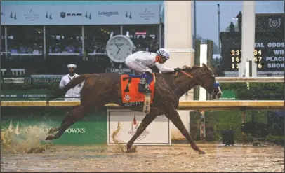  ?? The Associated Press ?? HISTORIC FINISH: Justify, ridden by jockey Mike Smith, wins the 144th Kentucky Derby, the wettest in history, on Saturday at Churchill Downs in Louisville, Ky. Diane Bondareff, Invision for Longines.