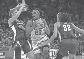  ?? ?? Texas forward Aaliyah Moore pushes past Alabama guards Sarah Barker and Aaliyah Nye during the Longhorns' NCAA second-round win Sunday. Texas will play Gonzaga on Friday night for a berth in the Elite Eight.