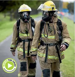  ?? PHOTO: DAVID UNWIN/STUFF ?? Palmerston North firefighte­rs Justin Storey and Jeremy Dodge walk down Pioneer Highway towards Wellington.