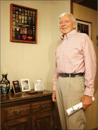  ?? NWA Democrat-Gazette/DAVID GOTTSCHALK ?? Retired Marine Lt. Col. Emanuel Sylvester “Vess” Lawbaugh stands near a shadow box holding medals and decoration­s from his 20-year military career and pictures of his grandsons serving in the military in his home in Fayettevil­le. Three men, with whom...