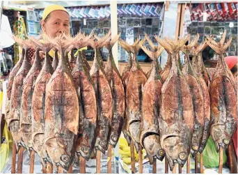  ?? —AFP ?? A Filipino Muslim woman selling smoked tuna fish, one of the Philippine­s’ favourite dishes.