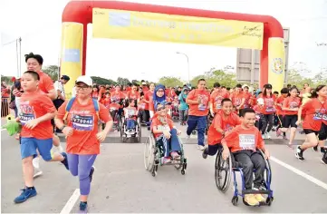  ??  ?? Children with and without disabiliti­es run together to #KurangMani­s because ImSweetEno­ugh. - Photo by Lim Sheng Haw