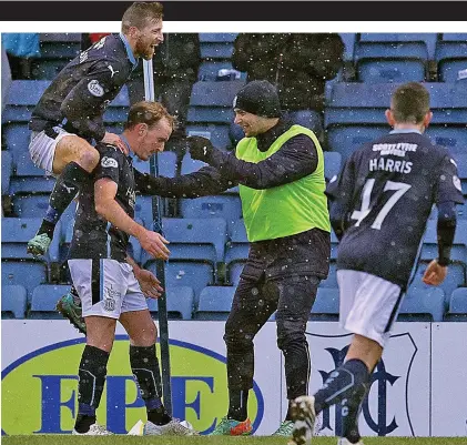  ??  ?? Three cheers: Gary Irvine (left) is congratula­ted after scoring Dundee’s third goal against Motherwell