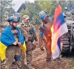  ?? ?? Ukrainian troops burn a Russian flag as they advance through the Kharkiv region
