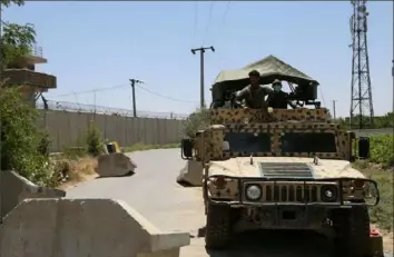  ?? Zakeria Hashimi/AFP via Getty Images/TNS ?? Afghan National Army soldiers stand guard at a road checkpoint outside Bagram Air Base, after all US and NATO troops left on July 2.