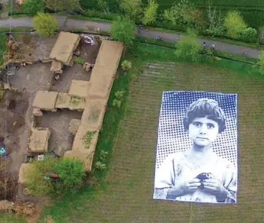  ?? INSIDE OUT PROJECT VIA AFP/GETTY IMAGES FILE PHOTO ?? A giant poster of a Pakistani girl whose parents, lawyers say, were killed in a drone strike, lies in a field in Pakistan in 2014. Such posters were placed in the country’s tribal regions by artists hoping to generate empathy among U.S. drone operators.