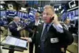  ?? RICHARD DREW — THE ASSOCIATED PRESS FILE ?? Trader George Ettinger, foreground, works on the floor of the New York Stock Exchange.