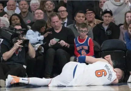  ?? MARY ALTAFFER — THE ASSOCIATED PRESS ?? Knicks forward Kristaps Porzingis lies on ground after tearing the ACL in his left knee against the Bucks, Tuesday at Madison Square Garden.