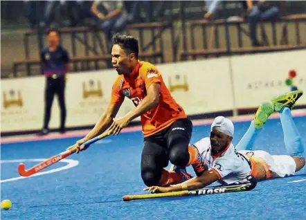  ?? — ABDUL RAHMAN EMBONG / The Star ?? No fair play: Malaysia’s Zulhamizan Mohamad is fouled by India’s Sukhjeet Singh in the Sultan of Johor Cup match at the Taman Daya Stadium last night.