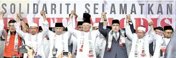  ?? — Bernama photo ?? Prime Minister Datuk Seri Najib Tun Razak (centre) with Deputy Prime Minister Datuk Seri Dr Ahmad Zahid Hamidi (third left) and members of NGOs raise their arms in a show of solidarity at the ‘Save Jerusalem' White Solidarity Rally at the Putra Mosque...