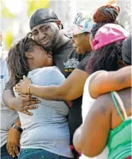  ?? THE ASSOCIATED PRESS ?? Veronica Trammell, left, is embraced outside a home where a fire Monday killed multiple people, including children, in Memphis.