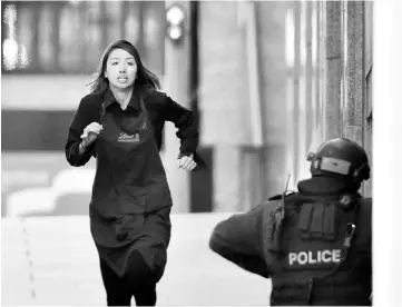  ?? — AFP photo ?? File photo shows one of the hostages running towards the police from a cafe in the central business district of Sydney during a siege.