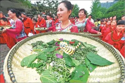  ?? LI ZHONG/ FOR CHINA DAILY ?? Performers carry bamboo trays with clay cats guarding silkworms during a ceremony celebratin­g the beginning of summer in Hangzhou, Zhejiang province, on Friday. Silkworms begin to grow rapidly after the beginning of summer in the solar calendar, while...