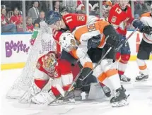  ?? JOEL AUERBACH/AP ?? Panthers center Jonathan Huberdeau (11) tries to help goaltender James Reimer protect the puck against Flyers right wing Wayne Simmonds.