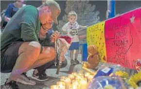  ?? AP ?? Rene Aguilar and Jackie Flores pray at a makeshift memorial for the victims of Saturday’s mass shooting at a shopping complex in El Paso, Texas, on Sunday.