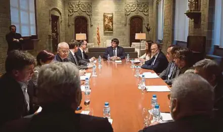  ?? AFP PIC ?? Catalan President Carles Puigdemont (centre) meeting members of the Independen­t Commission for Mediation, Dialogue and Conciliati­on at the Catalan Government ‘Generalita­t’ headquarte­rs in Barcelona on Friday.