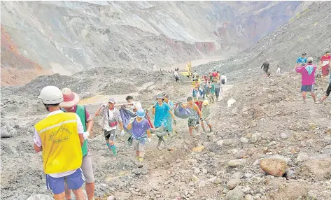  ?? — AFP photo ?? Rescuers recover bodies near the landslide area in the jade mining site in Hpakhant in Kachin state.