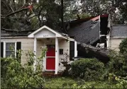  ?? MARK WILSON / GETTY IMAGES ?? A tree downed by Hurricane Florence lies on a home Sunday in Wilmington, North Carolina. The storm that hit as a Category 1 caused widespread damage and flooding in the Carolinas.