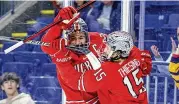  ?? AP ?? Ohio State’s Jake Wise (left) and Cam Thiesing celebrate after Thiesing scored a first-period goal against Harvard on Friday in Bridgeport, Conn. Thiesing had two goals, while Wise recorded four assists in the Buckeyes’ 8-1 win.