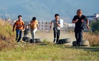  ??  ?? Le 17 novembre 2020, Zhu Zhihui (à d.) s’entraîne avec ses élèves près de l’École centrale de Matian.