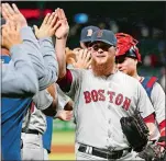  ?? MICHAEL AINSWORTH/AP PHOTO ?? Red Sox relief pitcher Craig Kimbrel is congratula­ted by teammates after Saturday’s 6-5 win over the Rangers at Arlington, Texas.