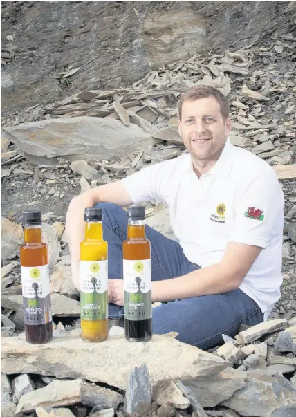  ??  ?? > Llyr Jones, proprietor of Blodyn Aur, with some of his new produce. Blodyn Aur produces Welsh rapeseed oil from its plant near Ruthin