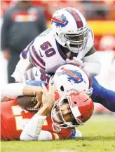  ?? Jamie Squire / Getty Images ?? Alex Smith is tackled by the Bills’ Jerry Hughes and Ramon Humber in Buffalo’s win.