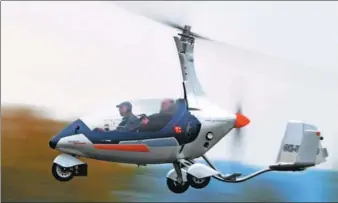  ?? MICHAL CIZEK / AGENCE FRANCE-PRESSE ?? Pavel Brezina (left) flies in his autogyro at the airport near Pribram in the Czech Republic. As global automakers vie to bring the first flying car to market, Brezina is trying a different tack by creating a car that can fly and also be driven legally...