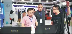  ?? ZHANG RAN / CHINA DAILY ?? A Beijing-based high-tech startup business representa­tive (far right) explains his company’s products to visitors at the ongoing China Beijing Internatio­nal High-Tech Expo.