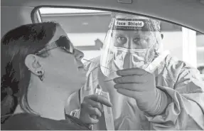  ?? JAY JANNER/USA TODAY NETWORK ?? A registered nurse takes a sample at a drive-thru COVID-19 test site in Austin, Texas, on Wednesday.