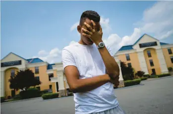  ?? JOHN MINCHILLO/AP ?? Mohamed, a 19-year-old fleeing political persecutio­n in the North African country of Mauritania, stands outside the Crossroads Hotel on Monday in Newburgh, N.Y.“IT’S like the desert,”he says of the locale.“there’s nothing here for us.”