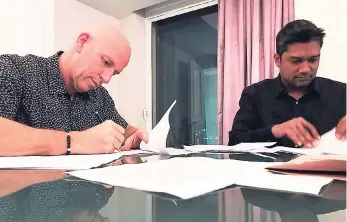  ??  ?? In this photo released in the week ending August 11, 2017, Managing Director of FranJam, Gary Matalon (left), and CDRG Chief Executive Officer Aly Esmail sign a franchise agreement to open 15 Usain Bolt Tracks & Records restaurant­s in the United...