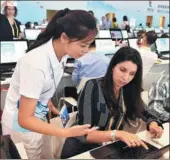  ?? NIAN QING / FOR CHINA DAILY ?? One of the more than 2,000 volunteers at the BRICS Summit assists a foreign reporter at the media center in Xiamen, Fujian province, on Sunday.