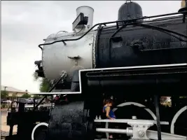  ?? YUMA SUN PHOTO ?? EMILY DROUET D’AUBIGNY OF TUCSON PLAYS IN THE DRY SPACES under the 1907 Baldwin locomotive at Pivot Point Plaza Wednesday morning.