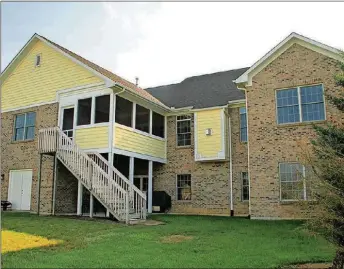  ??  ?? The lower level patio door off the family room opens to a covered concrete patio and backyard. Double doors open into the unfinished space, which has a workshop and garden storage.