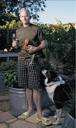  ?? Photos by Jason Henry / Special to The Chronicle ?? Winemaker-buyer Jim Denham with his dog and a chicken from his coop.