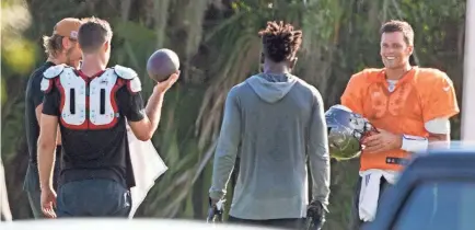  ??  ?? Buccaneers quarterbac­k Tom Brady, far right, is seen along with other players during a private workout Tuesday at Berkeley Preparator­y School in Tampa, Florida.