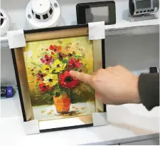  ??  ?? Photo shows a painting installed with a hidden camera on display at a spy camera shop in the port city of Incheon.